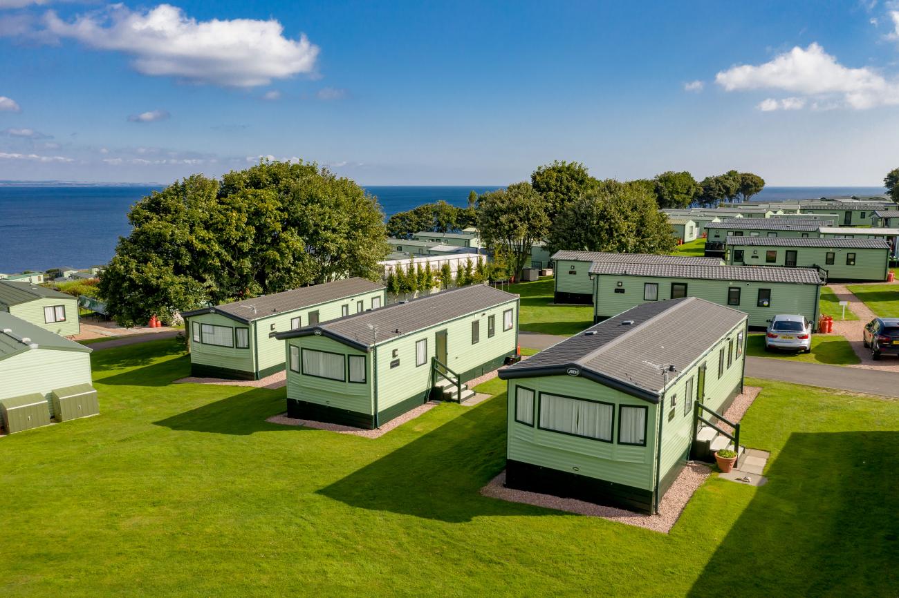 holiday homes on grass with sea in the distance