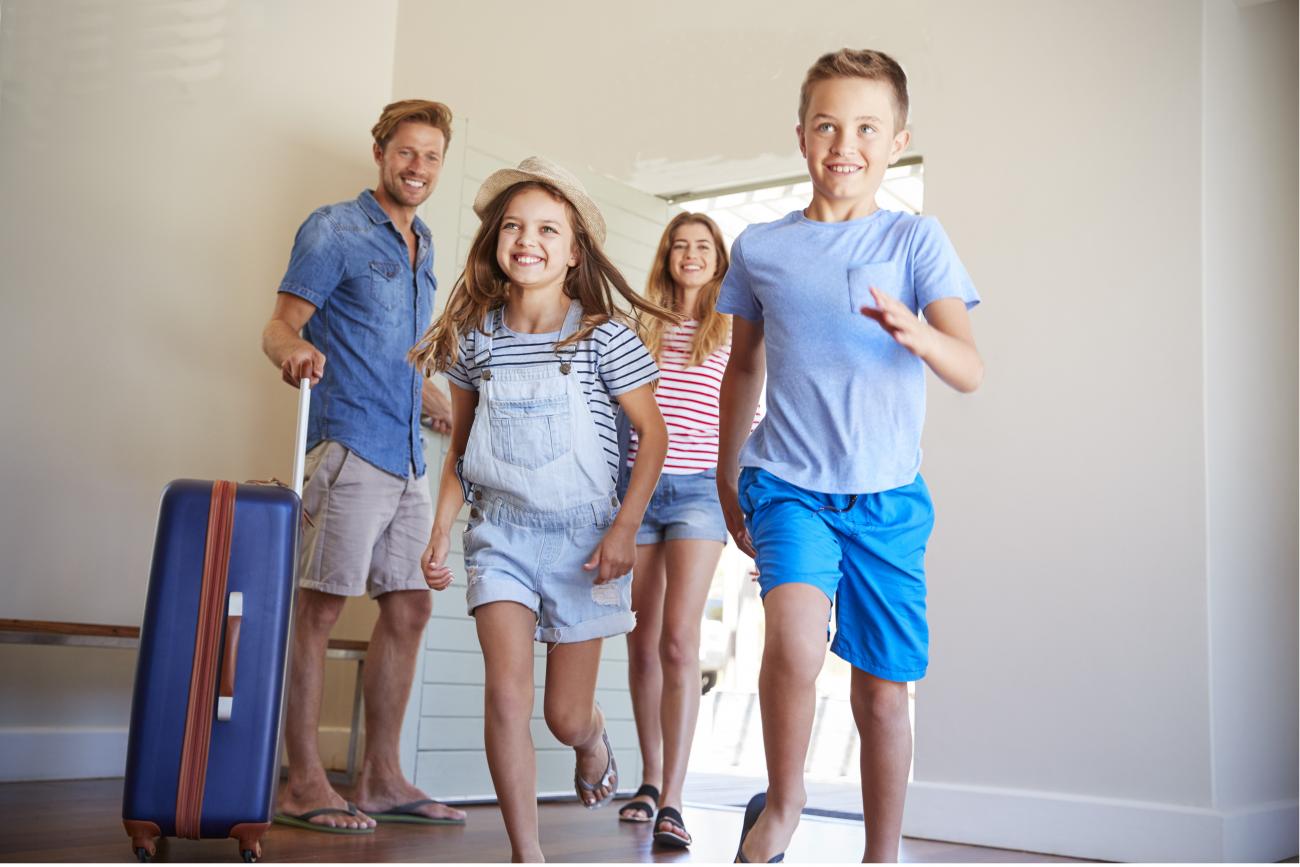 Family arriving at holiday home with luggage