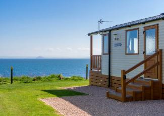 holiday homes on grass with sea in the distance