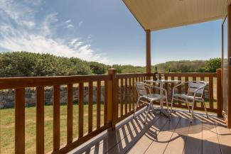 Open bottle of wine on patio table on sunny veranda